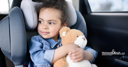little girl daughter child holding her teddy bear toy in the car